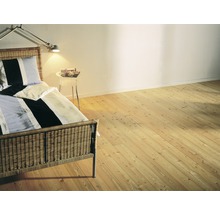 Schlafzimmer mit Holzboden, Bett und Nachttisch.