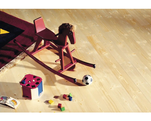 Holzboden mit Spielzeug, darunter ein Schaukelpferd, ein Ball und ein Formensortierer.