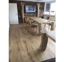 Esszimmer mit Holzboden, Tisch mit Baumstammfüßen, Holzstühlen und TV an einer Holzwand