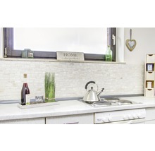 Helle Küche mit Fliesenwand, Getränken und Küchenutensilien auf der Arbeitsfläche