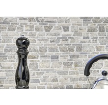 Mauer aus Steinimitat mit Pfeffermühle und Wasserkocher