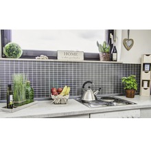 Küchenszene mit Accessoires und Utensilien auf einer Arbeitsfläche vor einer gefliesten Wand