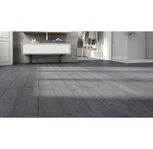 Badezimmer mit grauen Fliesen in Holzoptik, Waschtisch und Dusche.