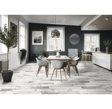 Esszimmer mit Esstisch, Stühlen und Bodenfliesen in Holzoptik.