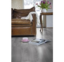 Wohnzimmer mit Ledersofa, Tisch, Tulpen und Laminatboden.