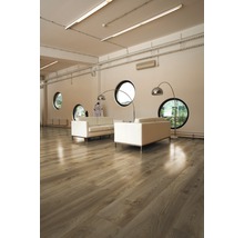 Heller Raum mit Holzboden, Sofas und runden Fenstern.