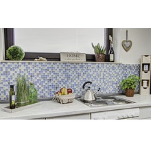 Küchenszene mit Mosaikfliesen, Dekoration und Kochutensilien auf einer Arbeitsplatte.