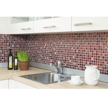 Küchenszene mit Mosaikfliesen, Spüle und Küchenutensilien auf der Arbeitsfläche.