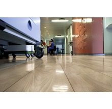 Heller Holzfußboden in einem Krankenhausflur mit medizinischen Geräten und Personal