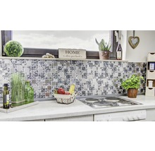 Detailaufnahme einer modernen Küche mit Mosaikfliesen als Spritzschutz, Herd und verschiedenen Dekorationsgegenständen.