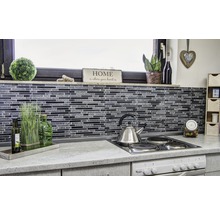 Küchenszene mit Mosaikfliesen, Edelstahlkessel und dekorativen Elementen.