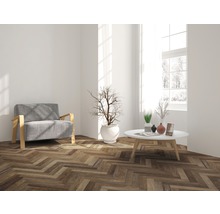 Wohnzimmer mit Sessel, Tisch und Parkettboden