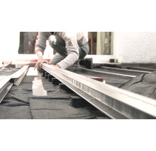 Person montiert Terrassendielen auf einer Unterkonstruktion.