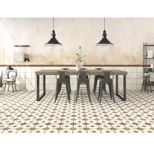 Heller Raum mit Esstisch, Stühlen, Fliesenboden mit Sternmuster und Pendelleuchten