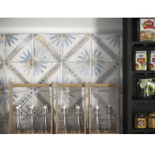 Wandfliesen mit floralem Muster und einem Regal mit Flaschen im Hintergrund.