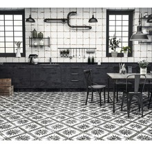 Küche mit dunklen Möbeln, Fliesenboden mit floralem Muster und Fenstern