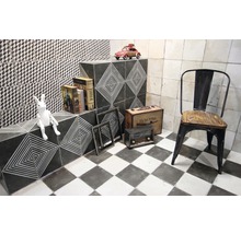 Dekoratives Badezimmer mit geometrischen Fliesen und Retro-Elementen wie Stuhl, Radio und Koffer