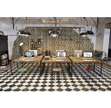 Büroraum mit Schreibtischen, Stühlen, Computern und Schachbrettboden