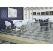 Einrichtung mit Bodenfliesen im grafischen Design, Tischen und Stühlen in einem Raum.