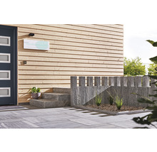 Eingangsbereich eines Gebäudes mit Holzfassade, Steintreppe und Pflastersteinen