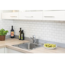 Küchenszene mit Spüle, Armatur, Fliesen und Küchenutensilien