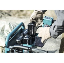 Ein Mann setzt einen Makita 18 Volt Akku in einen Werkzeugwagen