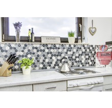 Küchenszene mit Mosaikfliesen in Hexagonform, Herd und Küchenutensilien.