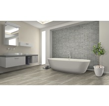 Badezimmer mit Badewanne, Waschtisch, Spiegel und grauen Fliesen