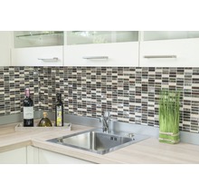 Küchenspüle mit Armatur, Mosaikfliesen und Dekorationen auf einer Arbeitsplatte.