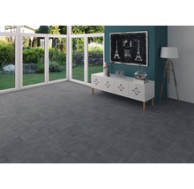 Heller Raum mit grauen Fliesen, weißen Fenstern und Kommode