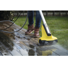 Person reinigt eine Holzterrasse mit einem Kärcher Terrassenreiniger