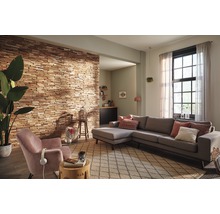 Wohnzimmer mit Holzverkleidung an der Wand, Ecksofa, Sessel und Teppich