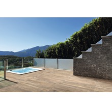 Terrasse mit Holzboden, Whirlpool und Steinmauer im Freien