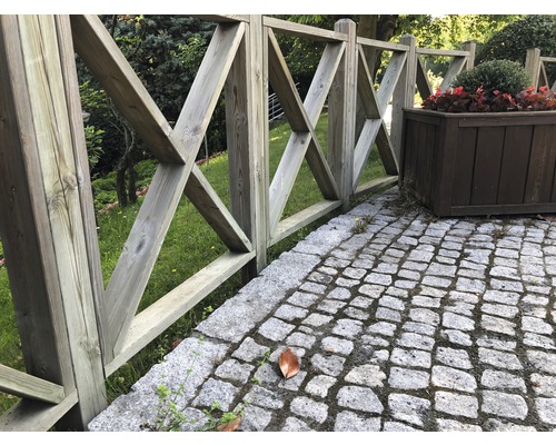 Gartenzaun aus Holz mit X-förmigem Design neben Pflanzkasten