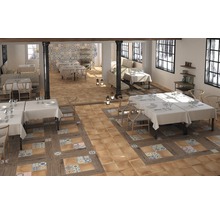 Innenansicht eines Restaurants mit Tischen, Stühlen und einem Bodenbelag aus Fliesen und Holz.