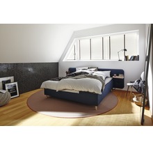 Schlafzimmer mit Bett, Teppich und dekorativen Elementen in einem hellen Dachgeschoss