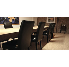 Esstisch mit Stühlen in einem Raum mit Steinwand