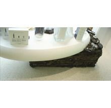 Präsentationstisch mit Hautpflegeprodukten und Dekor aus Lavastein