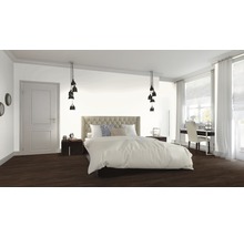 Schlafzimmer mit Bett, Nachttischen, Lampen und Arbeitsbereich am Fenster.