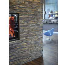 Wand mit Natursteinverblendung und Kamin im Wohnraum.