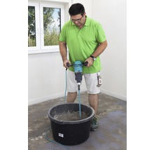 Mann mischt Material mit einem elektrischen Rührer in einem Eimer.