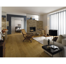 Heller Wohnraum mit Kamin, Holzfußboden, Couch, Sessel und Schiebetür zum Schlafzimmer