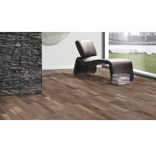 Moderner Raum mit Laminatboden, Sessel und Steinwand