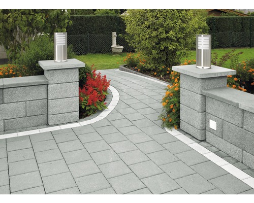 Gartenweg mit Pflastersteinen und Mauerelementen sowie zwei Leuchten