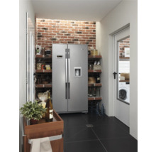 Küche mit Side-by-Side Kühlschrank, Regalen, Ziegelwand und schwarzem Fliesenboden