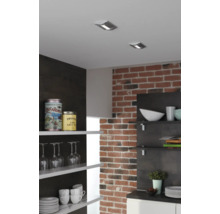 Küchenszene mit Deckenspots, Backsteinmauer und offenen Regalen mit Geschirr