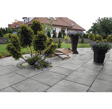 Terrasse mit Pflastersteinen, Gartenmöbeln und Pflanzen