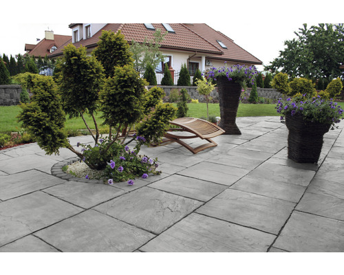 Terrasse mit Pflastersteinen, Gartenmöbeln und Pflanzen