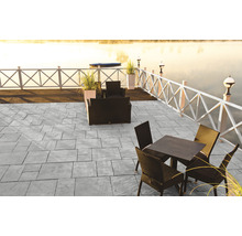 Terrasse mit grauen Steinplatten und Gartenmöbeln am See