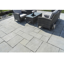 Terrasse mit hellen Terrassenplatten und Gartenmöbeln